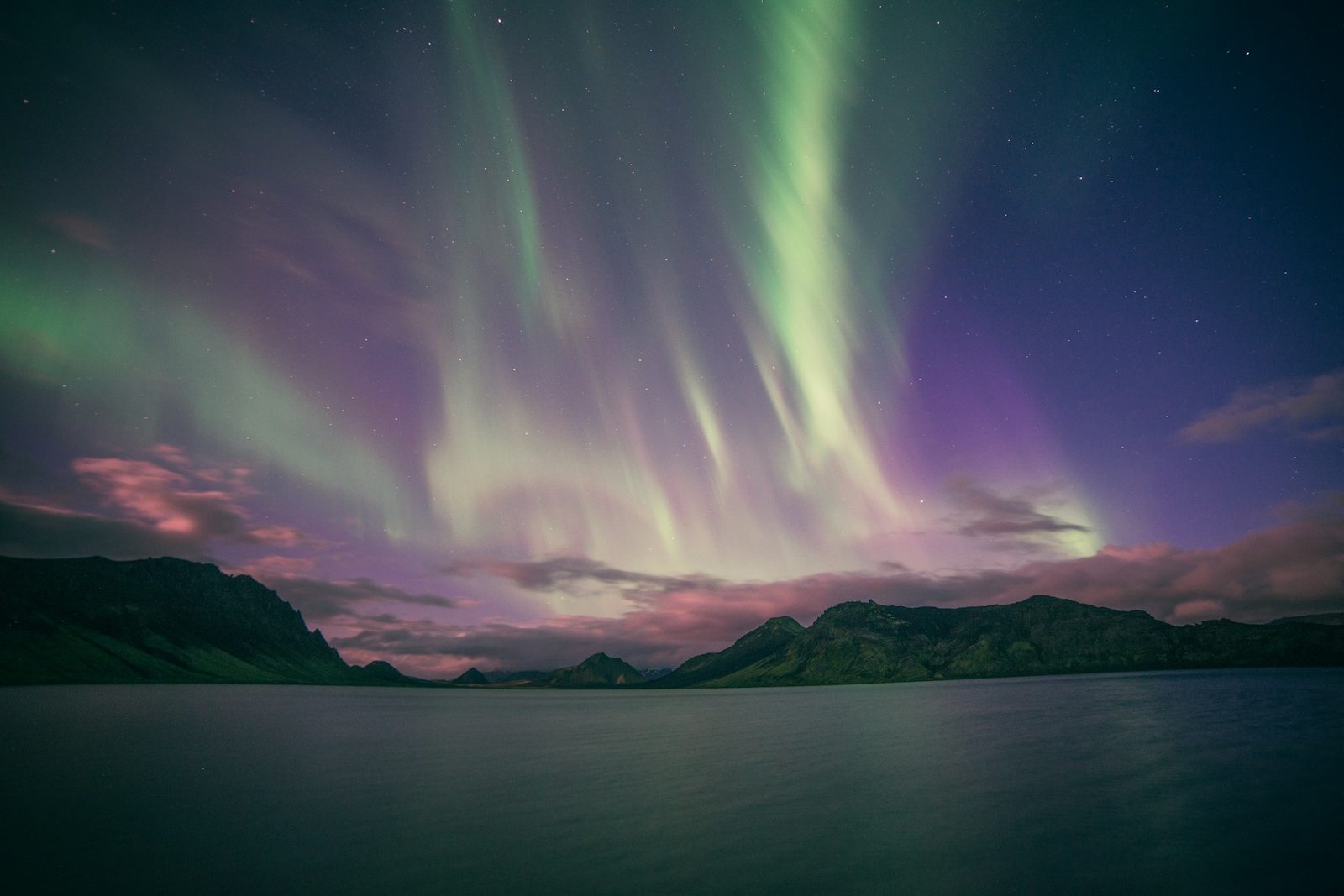 Aurora boreal verde y violeta sobre un lago en Islandia