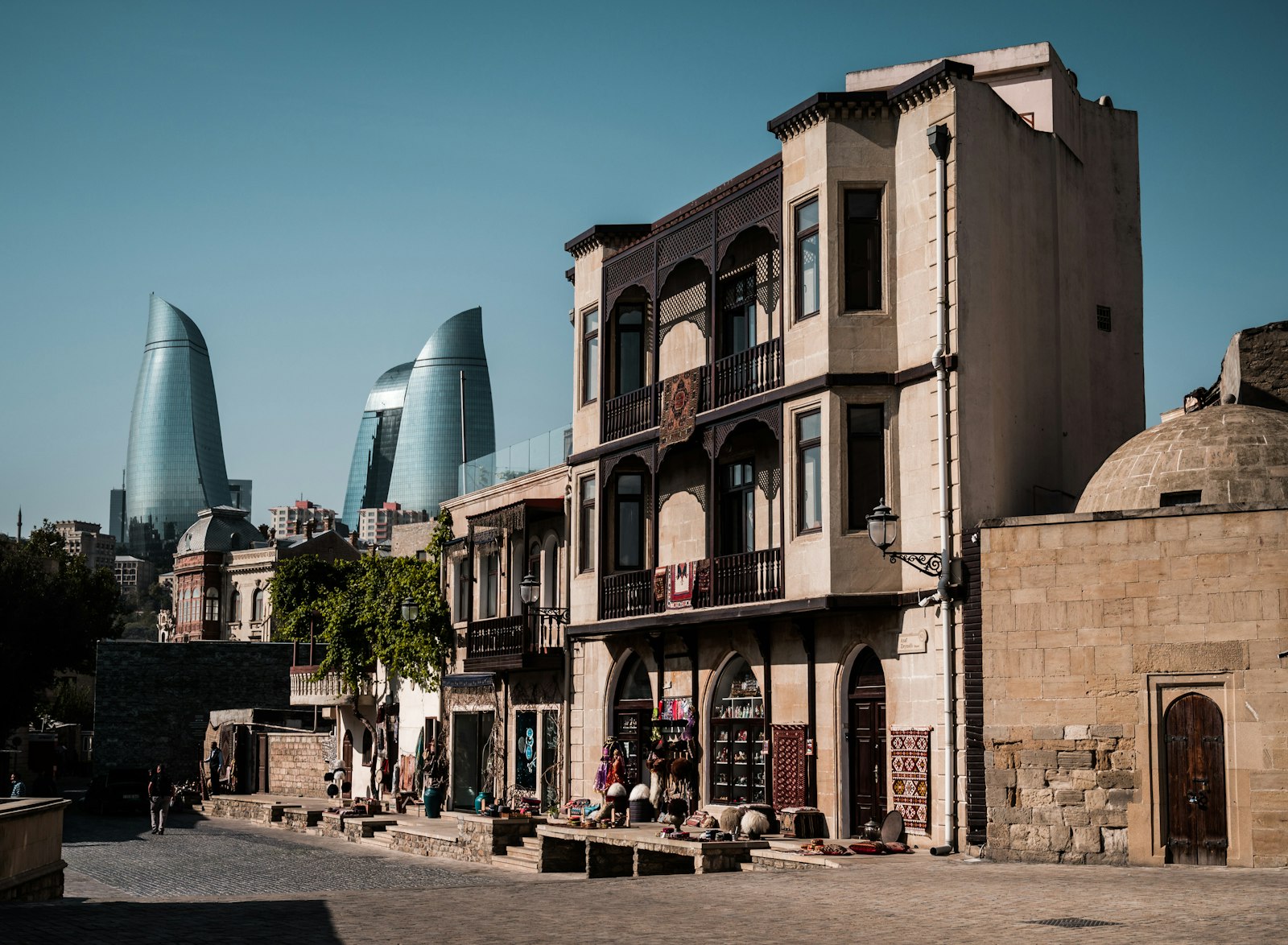 Casa tradicional con balcones de madera en la ciudad vieja de Bakú, con las Flame Towers al fondo