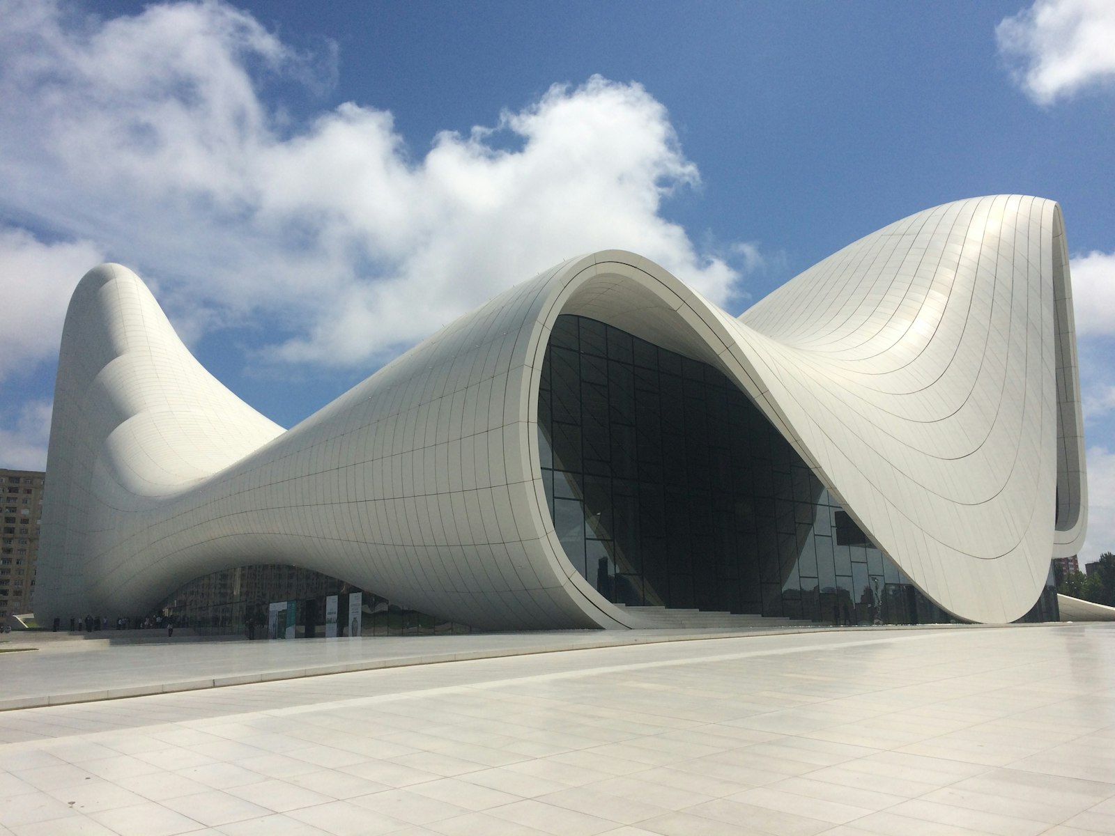 Fachada blanca y curva del Centro Heydar Aliyev en Bakú bajo un cielo azul