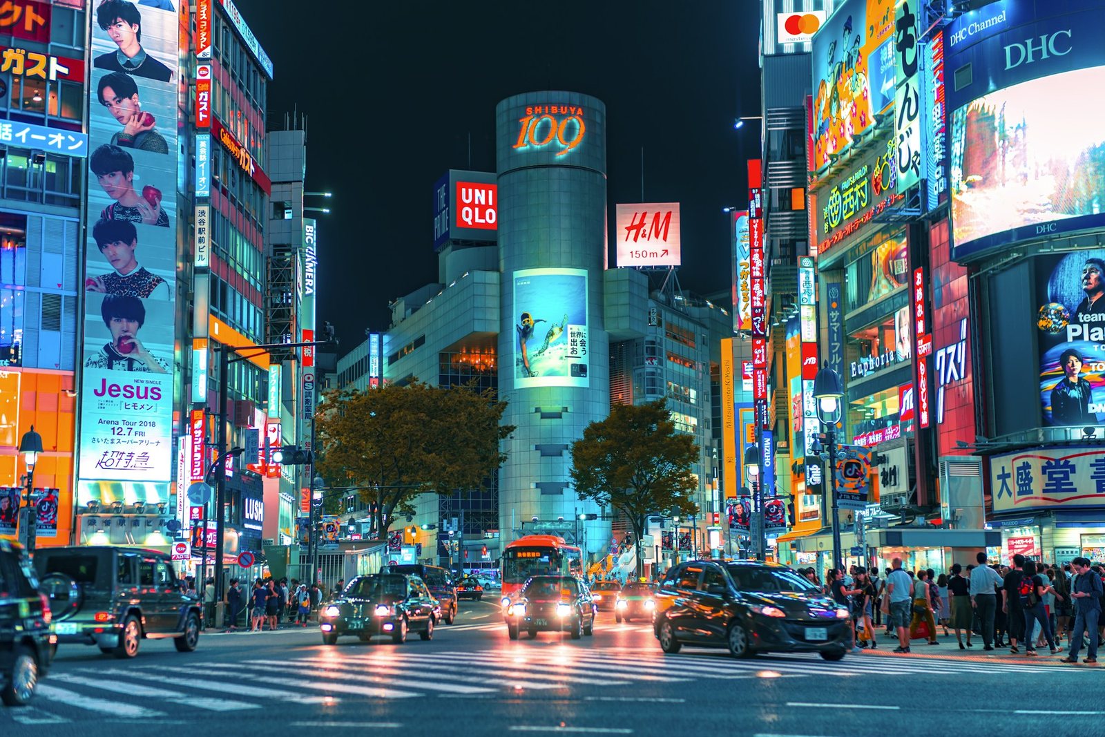 Cruce de Shibuya en Tokio de noche, con avisos luminosos y carros en movimiento
