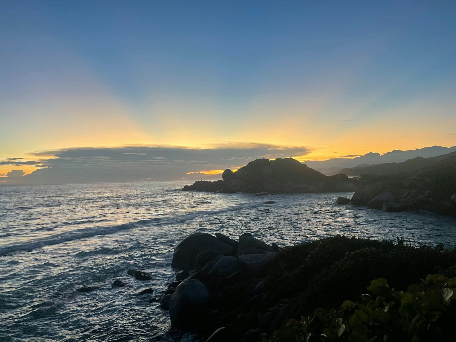 Atardecer sobre el mar y las rocas de la costa del Tayrona