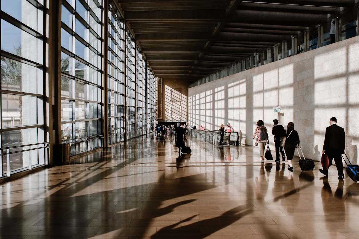 Viajeros con maletas caminando por la terminal de un aeropuerto