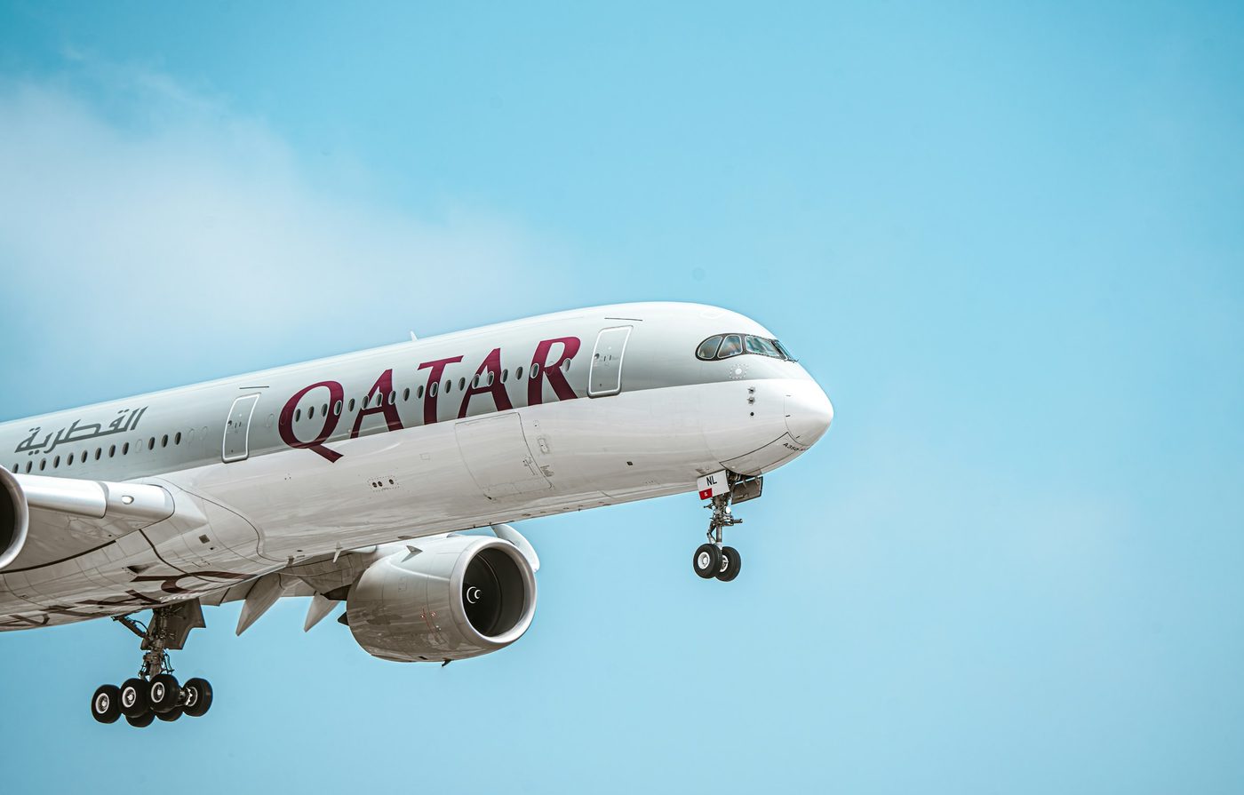 Avión de Qatar Airways en aproximación, con la librea granate y blanca de la aerolínea