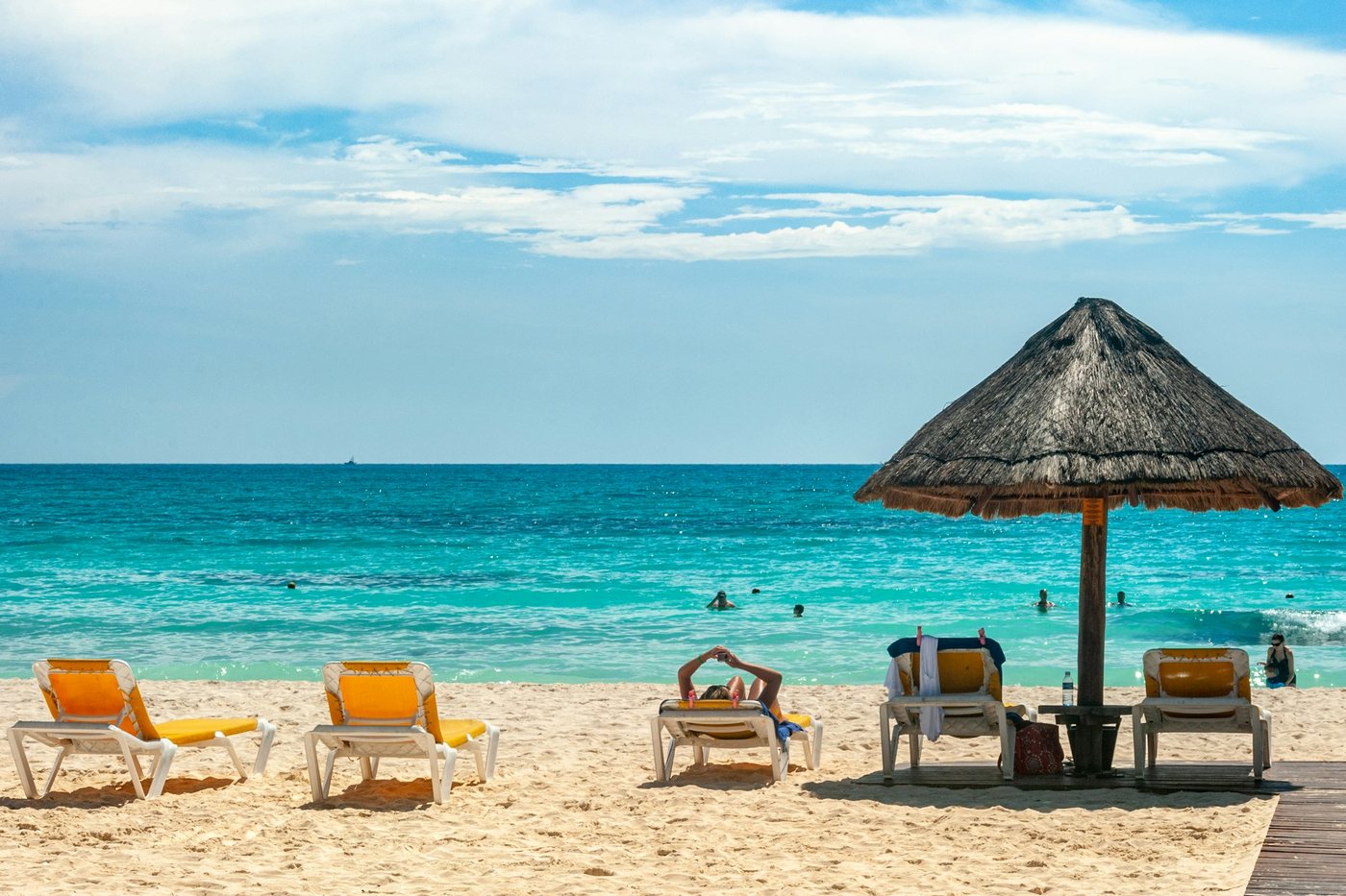 Playa con sombrilla de palma y mar turquesa en el Caribe mexicano