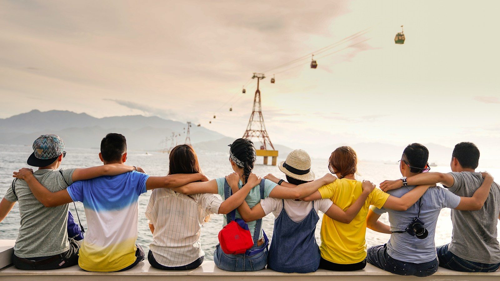 Grupo de viajeros abrazados mirando un valle desde un mirador