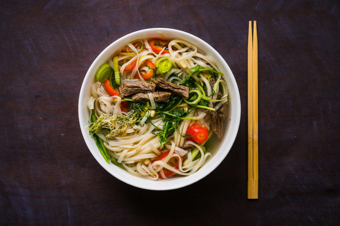 Plato de pho bo, sopa vietnamita de fideos de arroz con carne de res, hierbas y ají, vista desde arriba