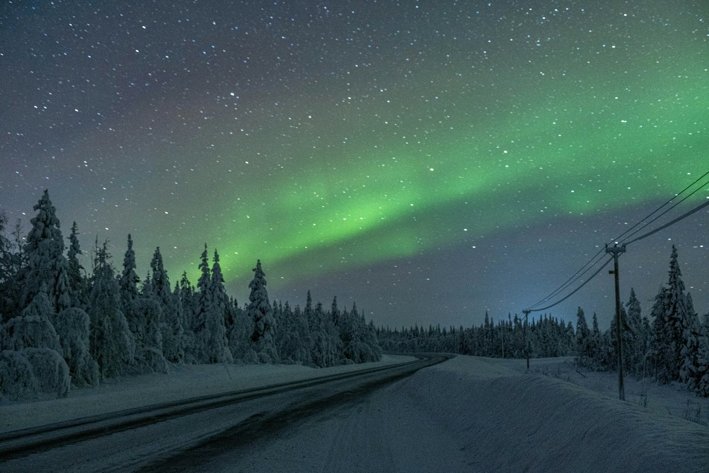 Aurora boreal verde sobre una carretera nevada de Islandia
