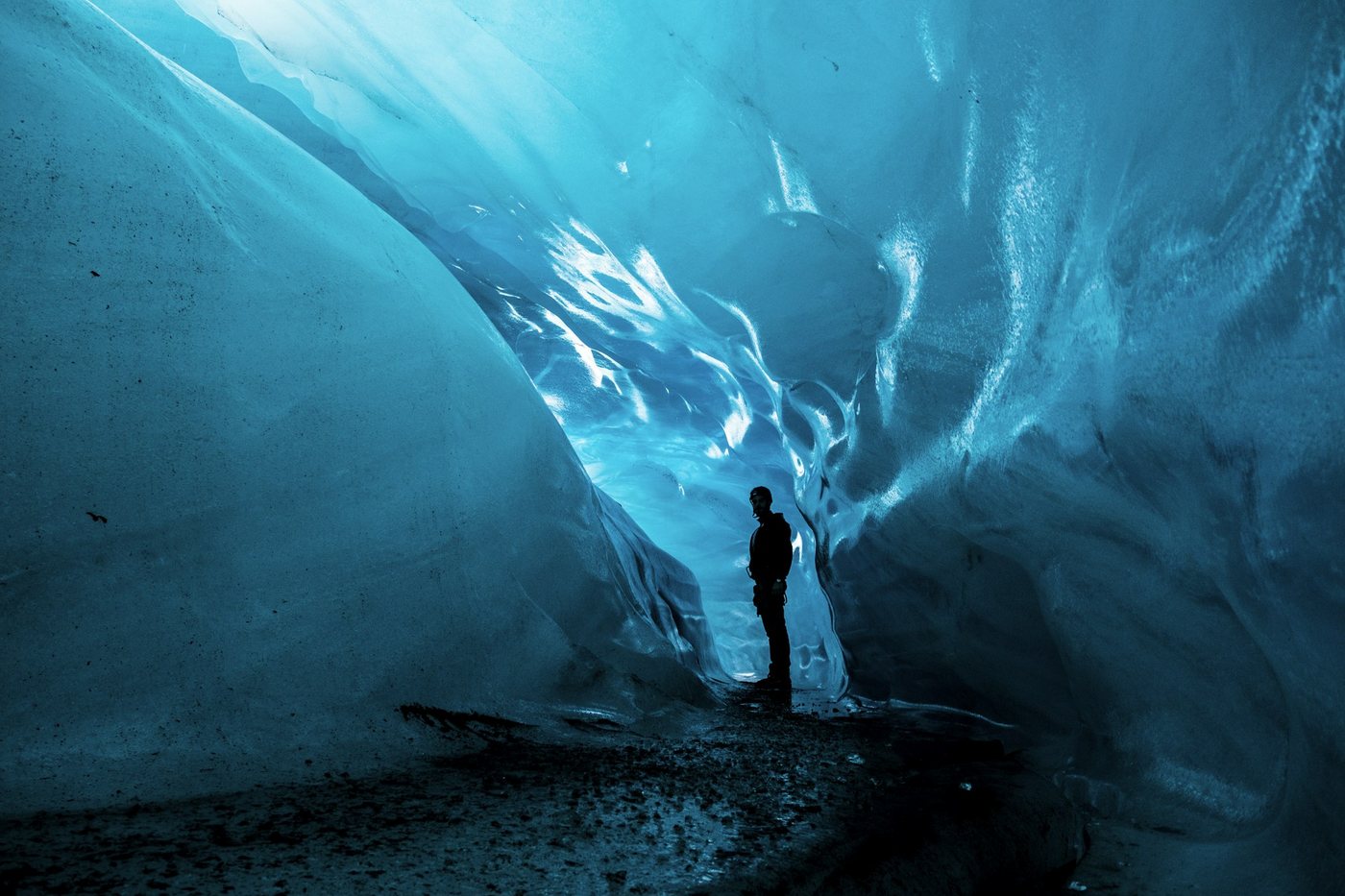 Una persona dentro de una cueva de hielo azul en un glaciar de Islandia