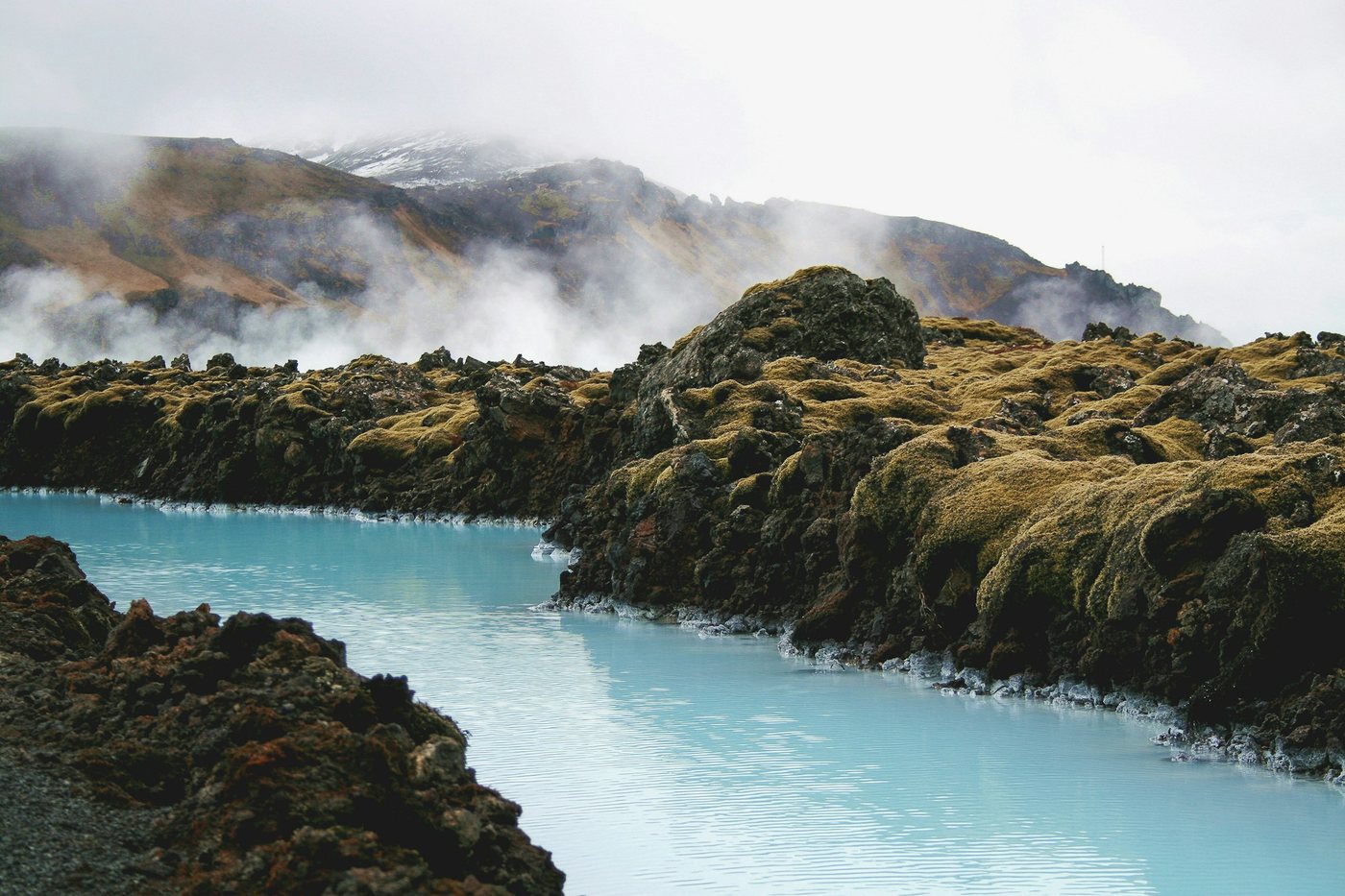 Aguas turquesa y vapor en la Laguna Azul, rodeada de campos de lava