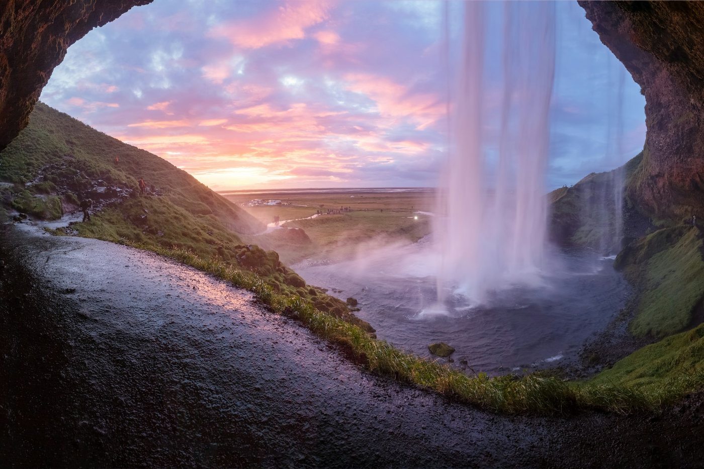 La cascada de Seljalandsfoss vista desde la cueva que hay detrás del salto de agua, al atardecer