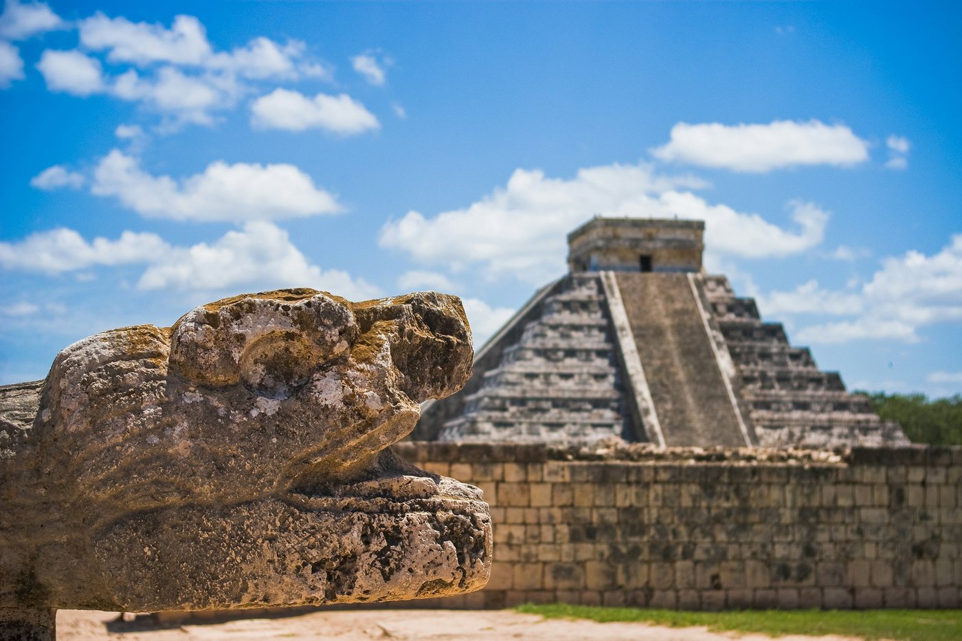 Pirámide de Kukulkán en Chichén Itzá con una cabeza de serpiente de piedra en primer plano