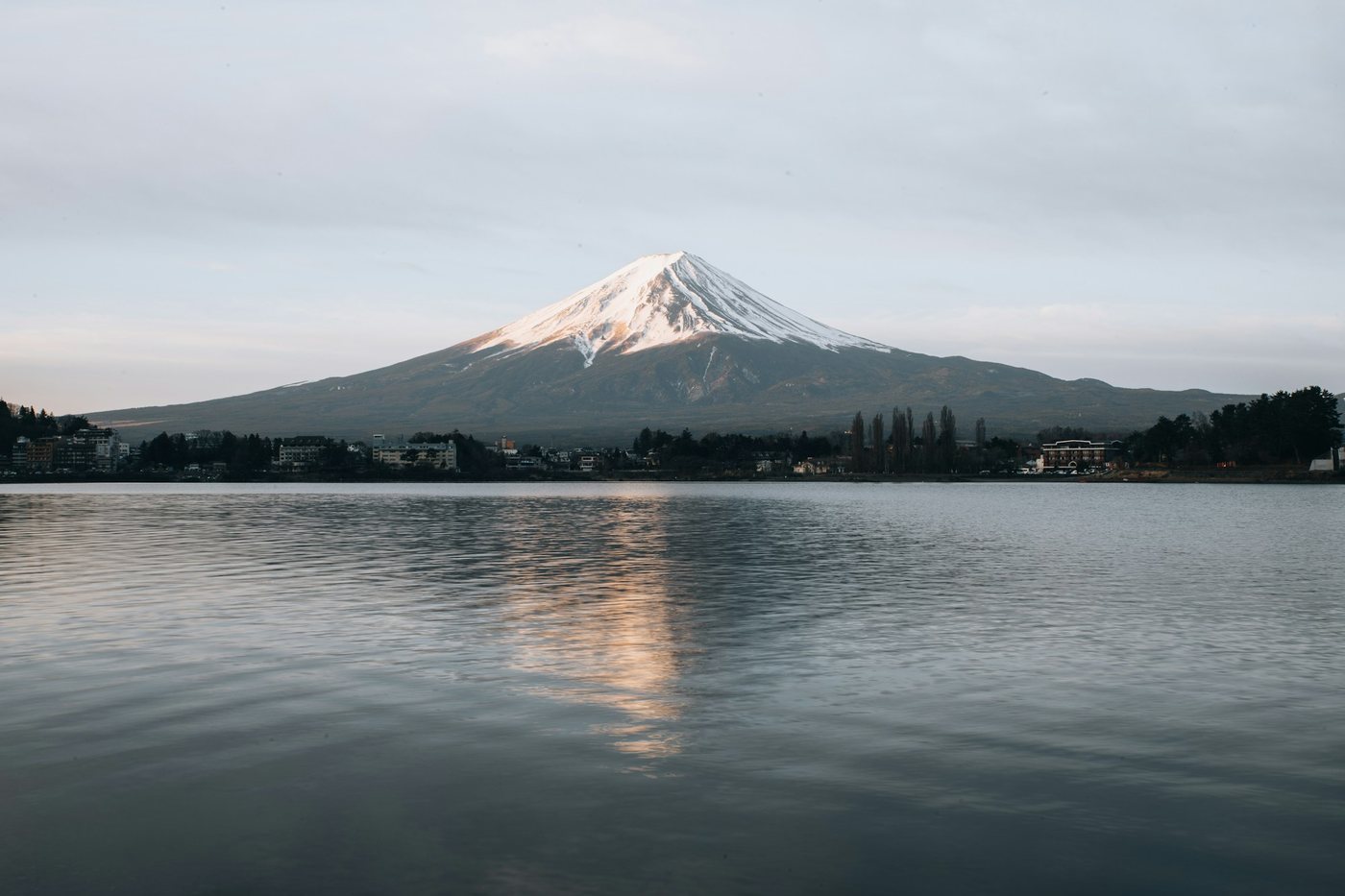El monte Fuji con nieve en la cima reflejado en un lago