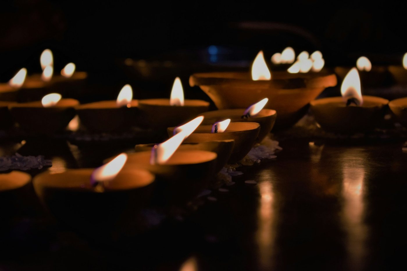 Decenas de velas pequeñas encendidas en la oscuridad